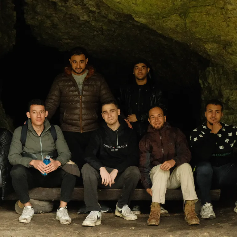 Group picture of men sitting in a cave